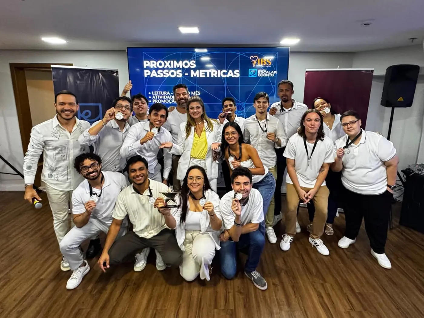Time da Escalar Odonto reunido, segurando medalhas de reconhecimento ao fim de um ciclo de metas